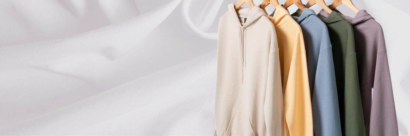 Row of colorful hoodies hanging on a rack against a white background