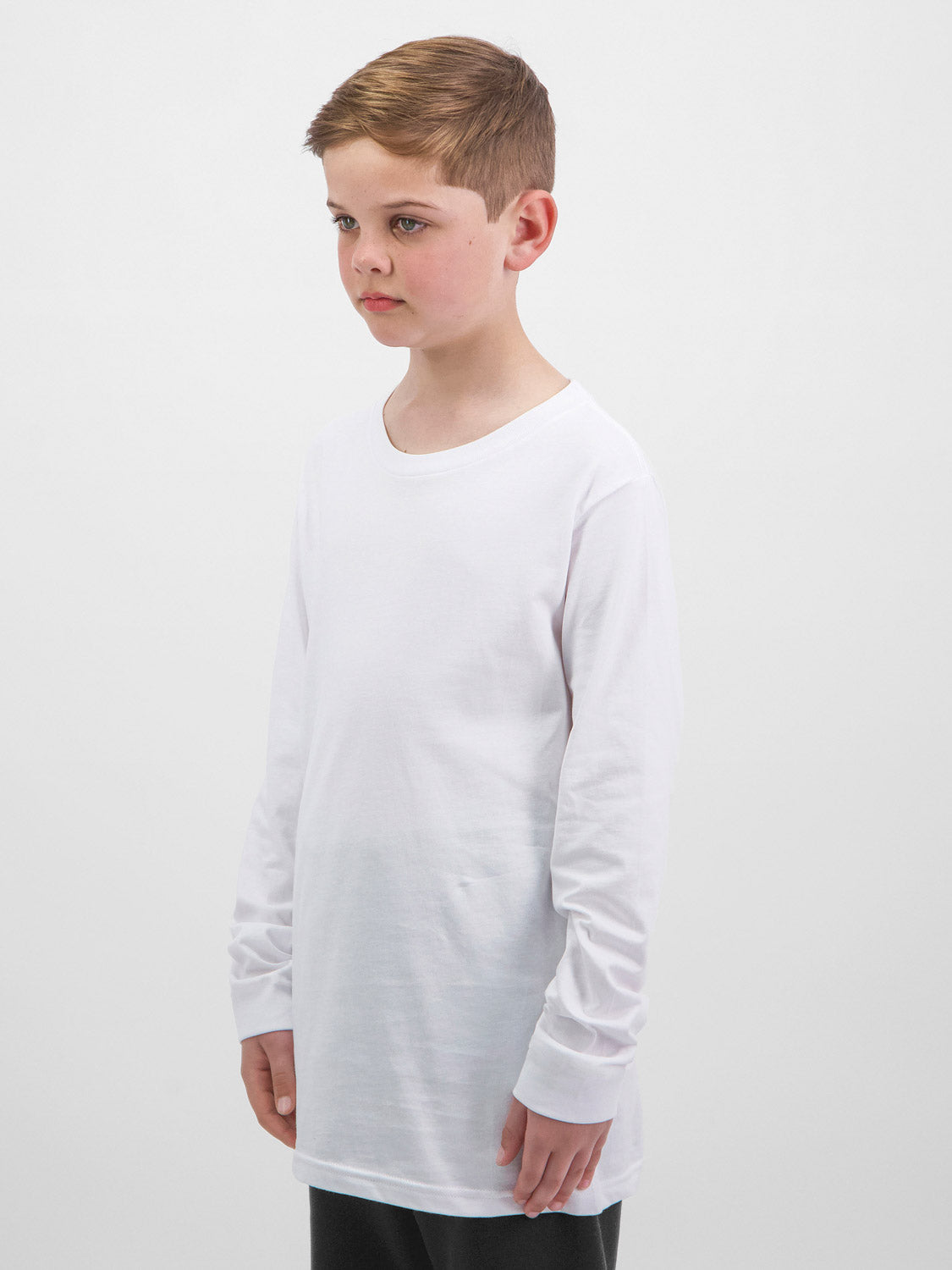 A young boy wearing a white long-sleeve cotton t-shirt against a plain white background.