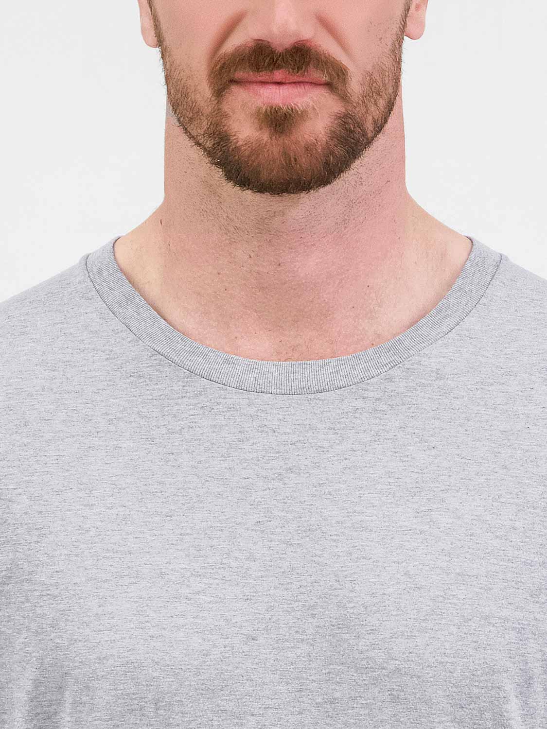Close-up of a man wearing a grey long sleeve tee with a ribbed crew neckline.