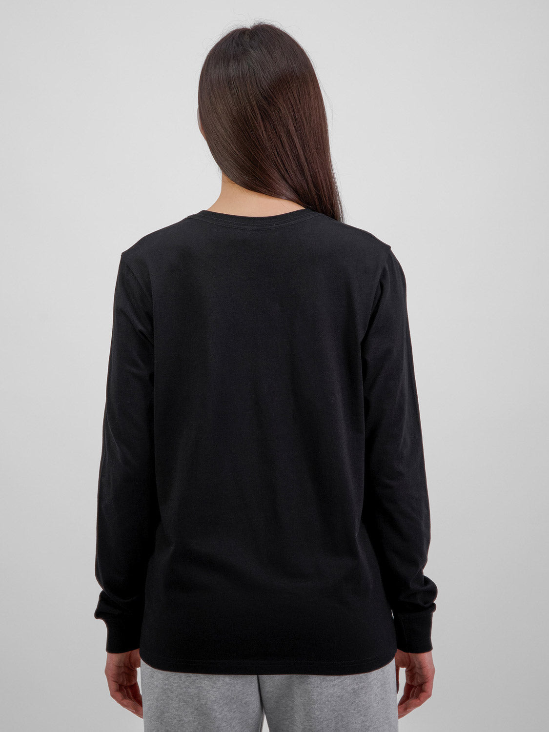 Rear view of a woman wearing a black long sleeve cotton t-shirt with ribbed cuffs.