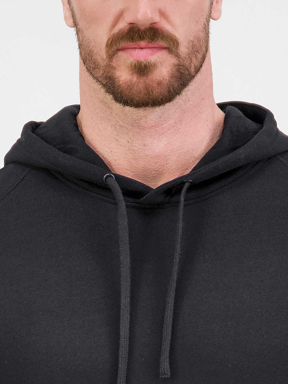 Close-up of a man wearing a black Mens Basis Hoodie with an adjustable drawcord hood.