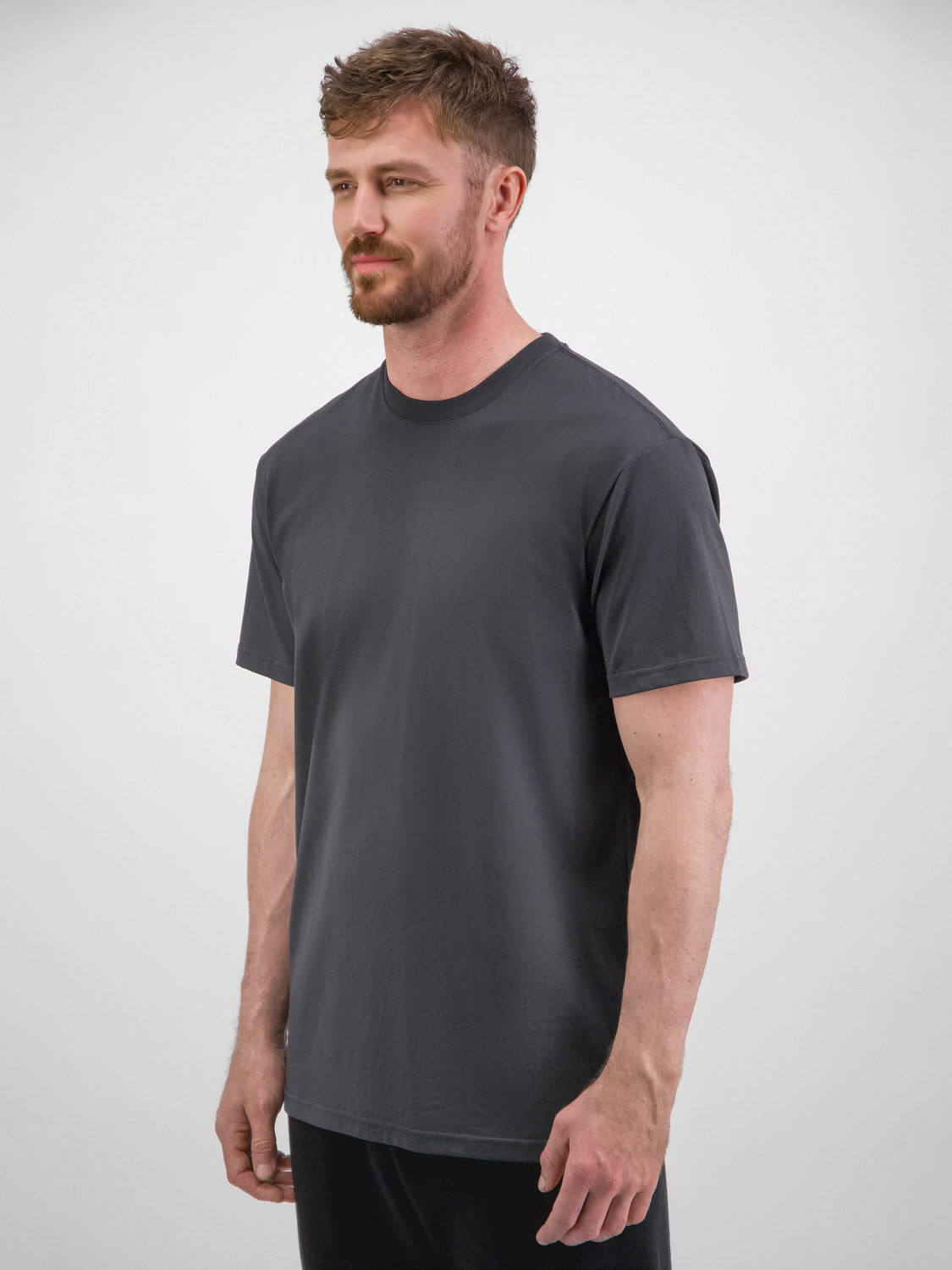 A man wearing a charcoal grey, short-sleeve cotton crewneck t-shirt with a relaxed fit.