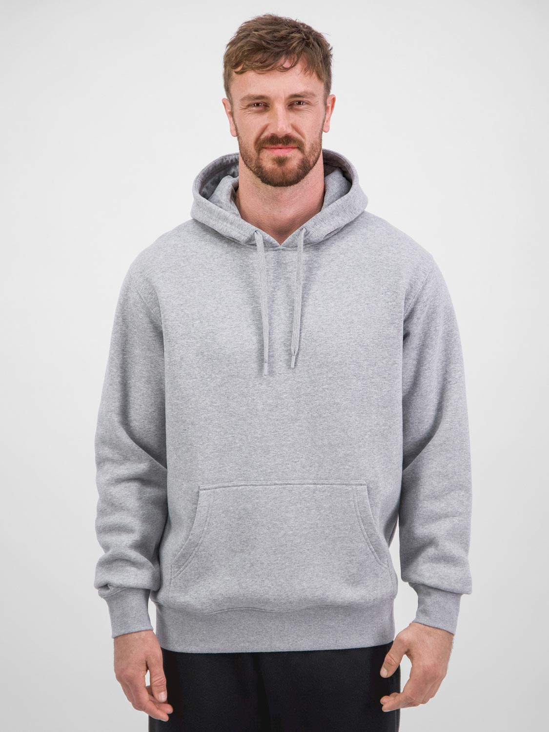 A man wearing a classic grey heathered hoodie with a front kangaroo pocket and ribbed cuffs.
