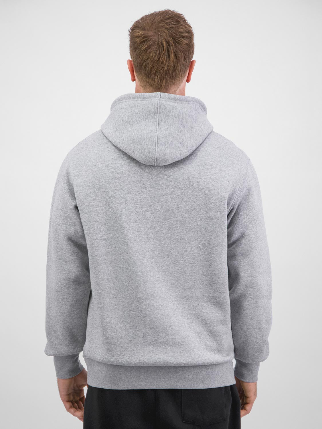 Rear view of a man wearing a grey heavy-weight hoodie with ribbed cuffs and waistband.
