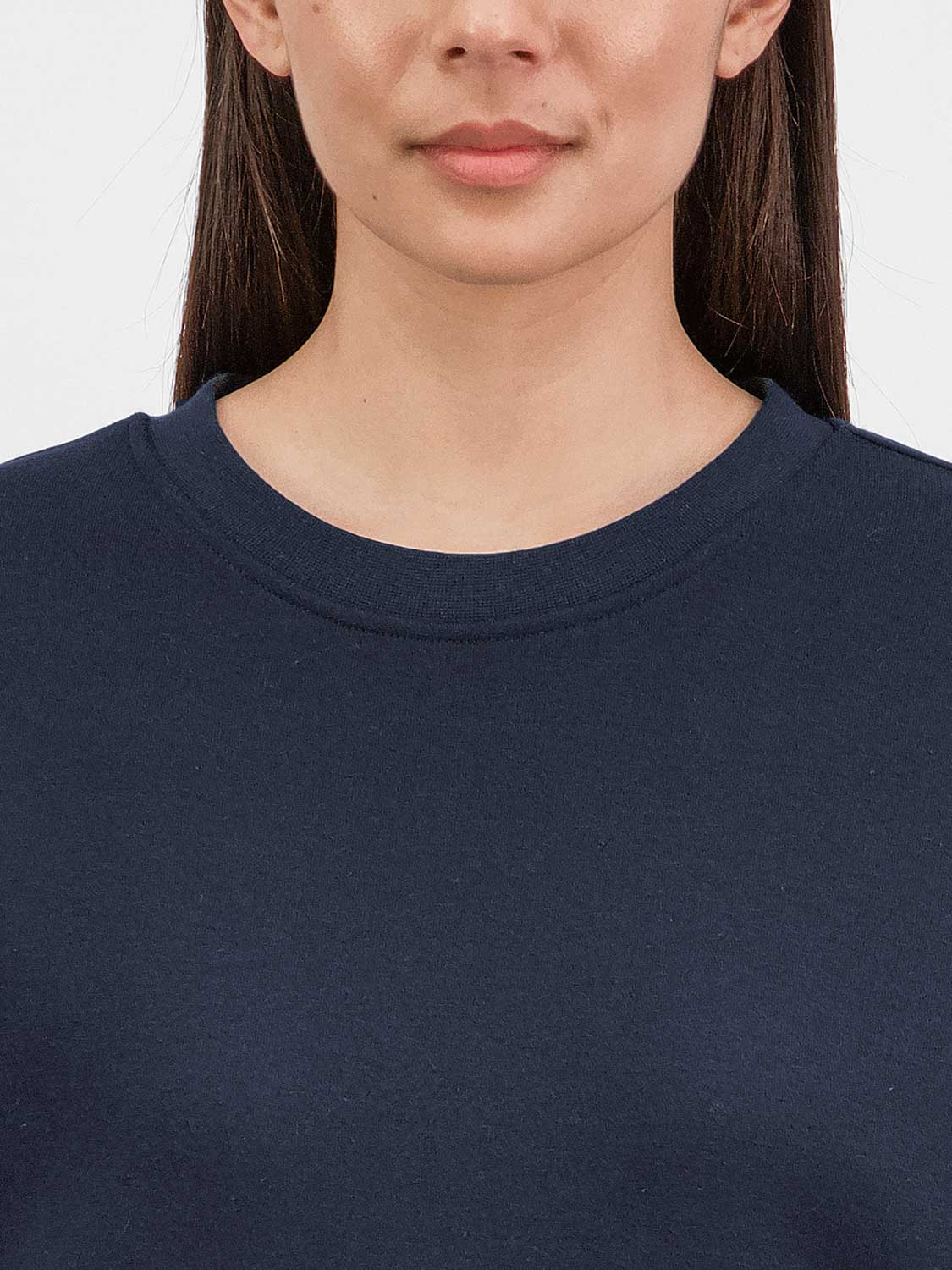 Close-up of a woman wearing a navy blue crew neck sweatshirt made of soft brushed fleece.