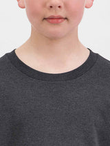 Close-up of a child wearing a dark charcoal grey cotton t-shirt with a ribbed crew neckline.