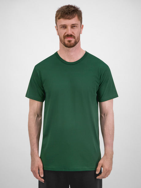 A man wearing a dark green, short-sleeve cotton crew neck t-shirt against a plain grey background.