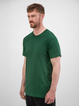 A man wearing a dark green, short-sleeve cotton crew neck t-shirt against a white background.