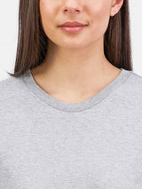 Close-up of a woman wearing a grey short sleeve tee with a ribbed crew neckline.