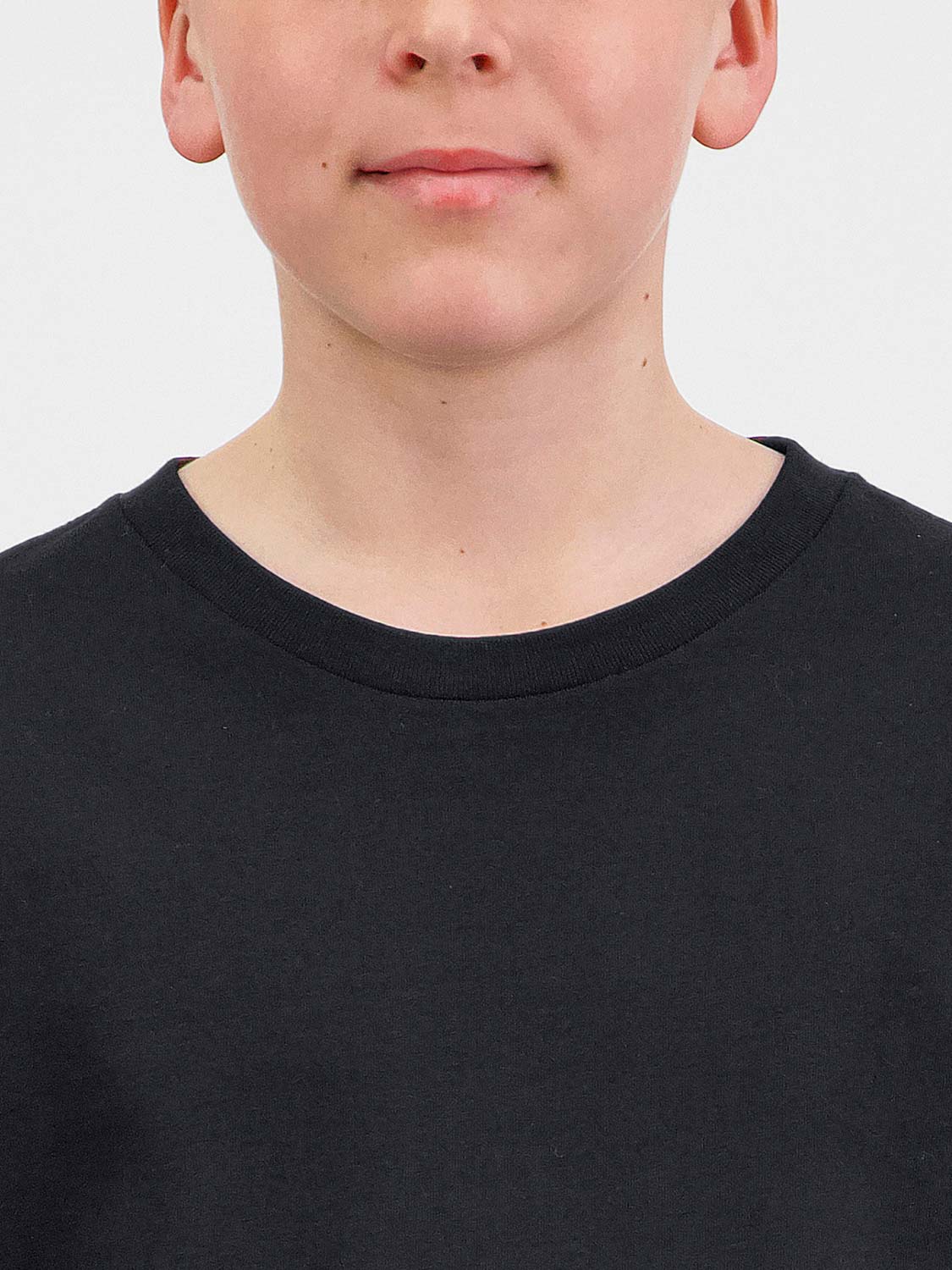 Close-up of a youth wearing a black short sleeve tee with a ribbed crew neckline.