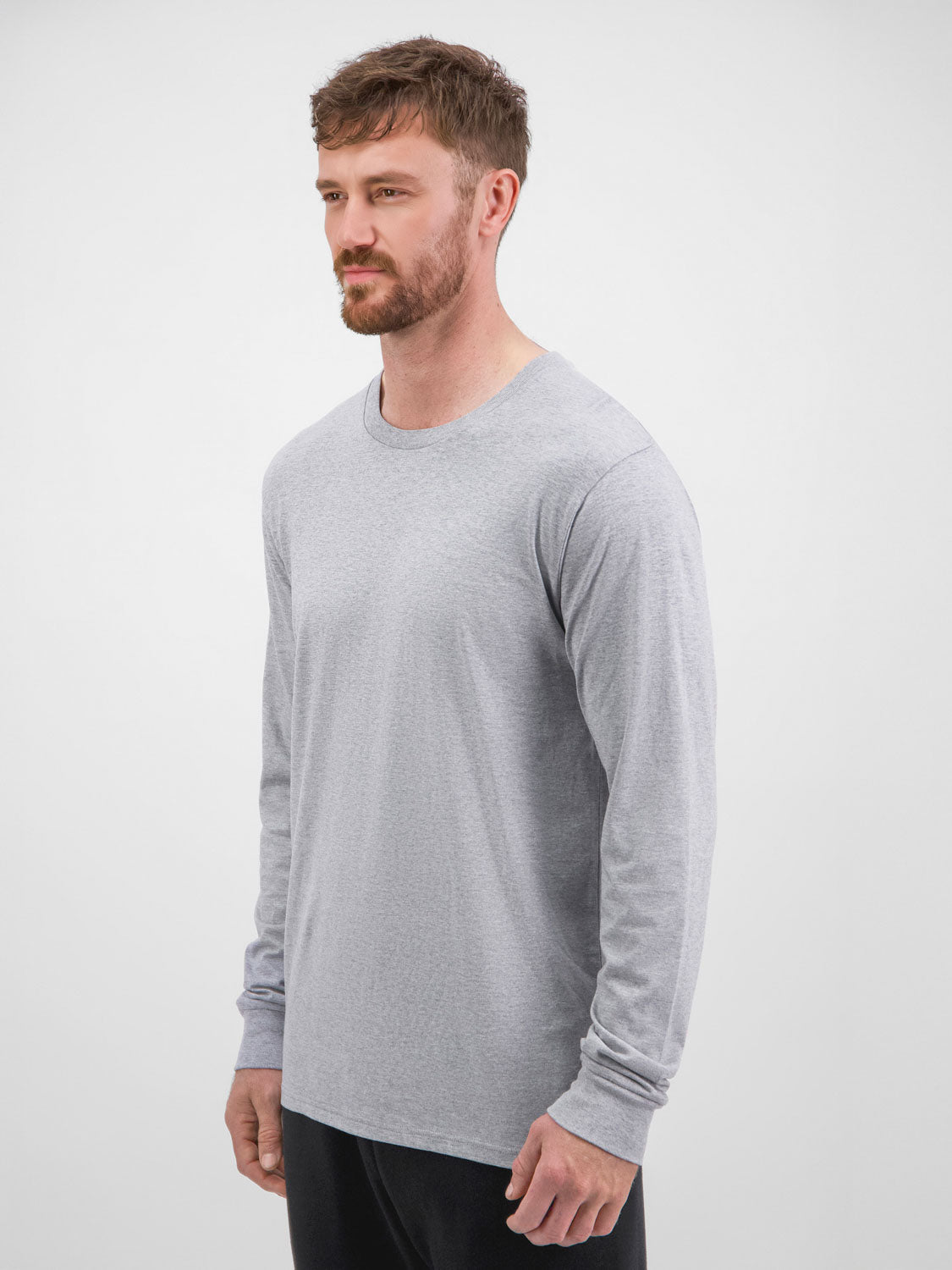 A man wearing a light grey long sleeve crew neck t-shirt with a classic fit.