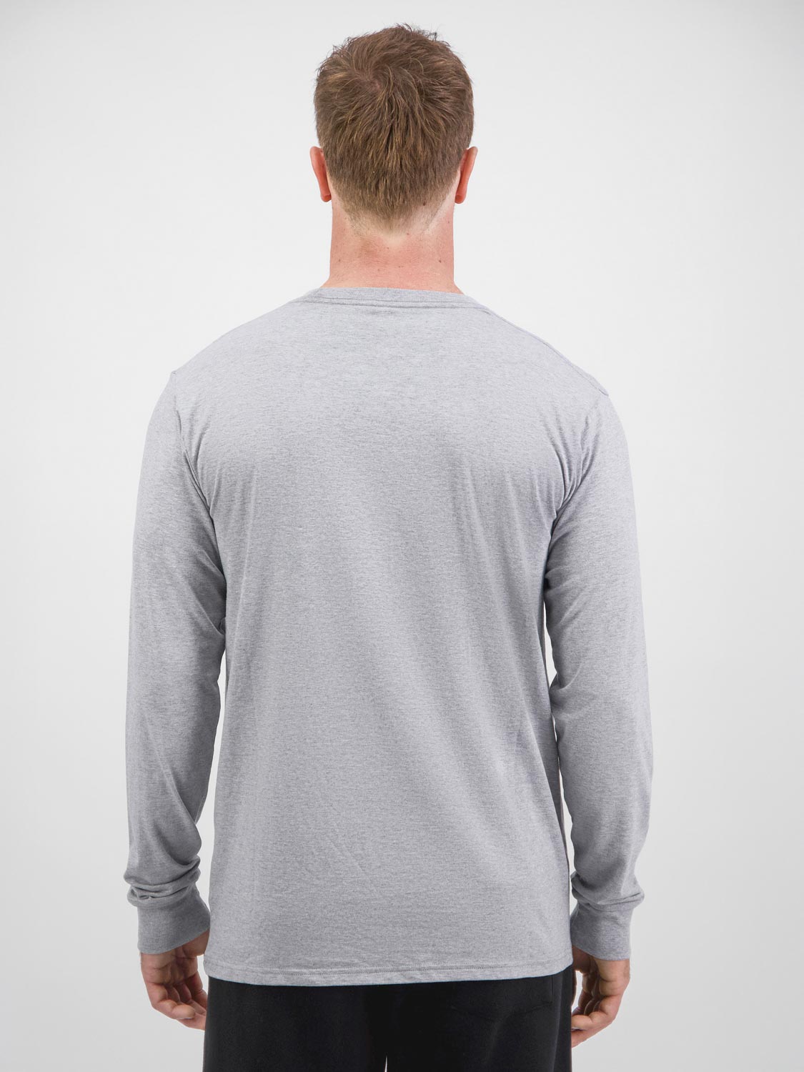 Rear view of a man wearing a grey long sleeve cotton t-shirt and black pants.