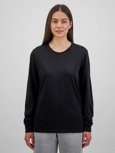A woman wearing a black long-sleeve cotton tee with a ribbed crew neck and cuffs.