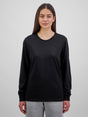 A woman wearing a black long-sleeve cotton tee with a ribbed crew neck and cuffs.