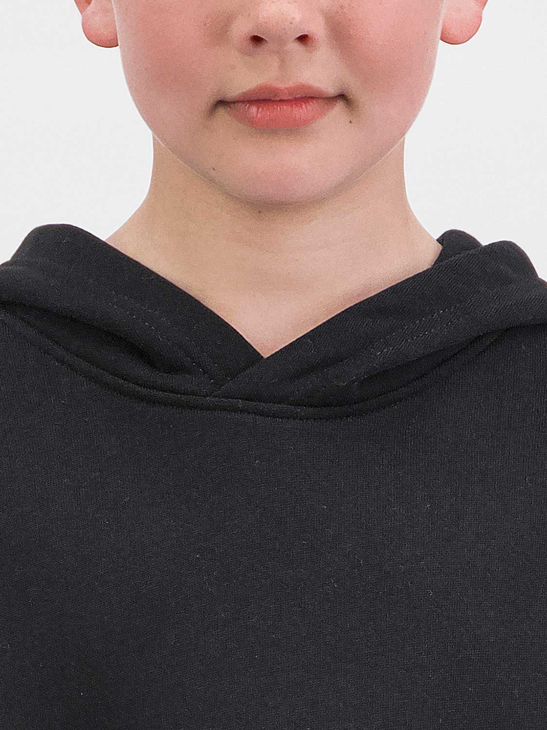 Close-up of a child wearing a black hooded sweatshirt with a crossover neckline.