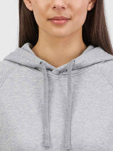 Close-up of a woman wearing a light grey marle hoodie with adjustable drawcords.