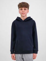A young person wearing a navy blue Youth Basis Hoodie with a front kangaroo pocket.
