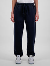 A person wearing navy blue relaxed-fit fleece track pants with an elastic drawstring waistband.