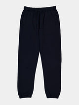 Womens navy blue relaxed fit track pants with an elastic drawstring waist and cuffed ankles.