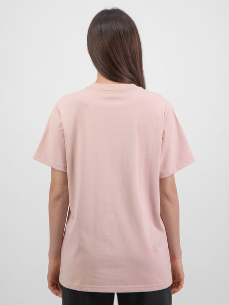 Rear view of a woman wearing a relaxed-fit, light pink short sleeve t-shirt with a crew neckline.