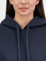 Close-up of a woman wearing a navy blue hoodie with matching drawstrings and a soft fleece texture.