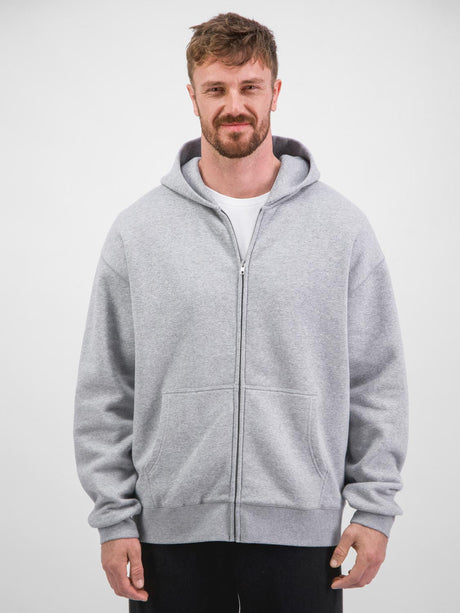 A man wearing a grey zip-up hoodie with a front pocket and ribbed cuffs.