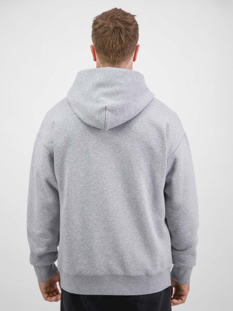 Rear view of a man wearing a grey heavyweight zip hoodie with a relaxed fit and ribbed hem.