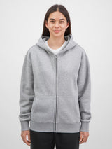 A woman wearing a grey Everyday Zip Hoodie with a relaxed fit and front pockets.