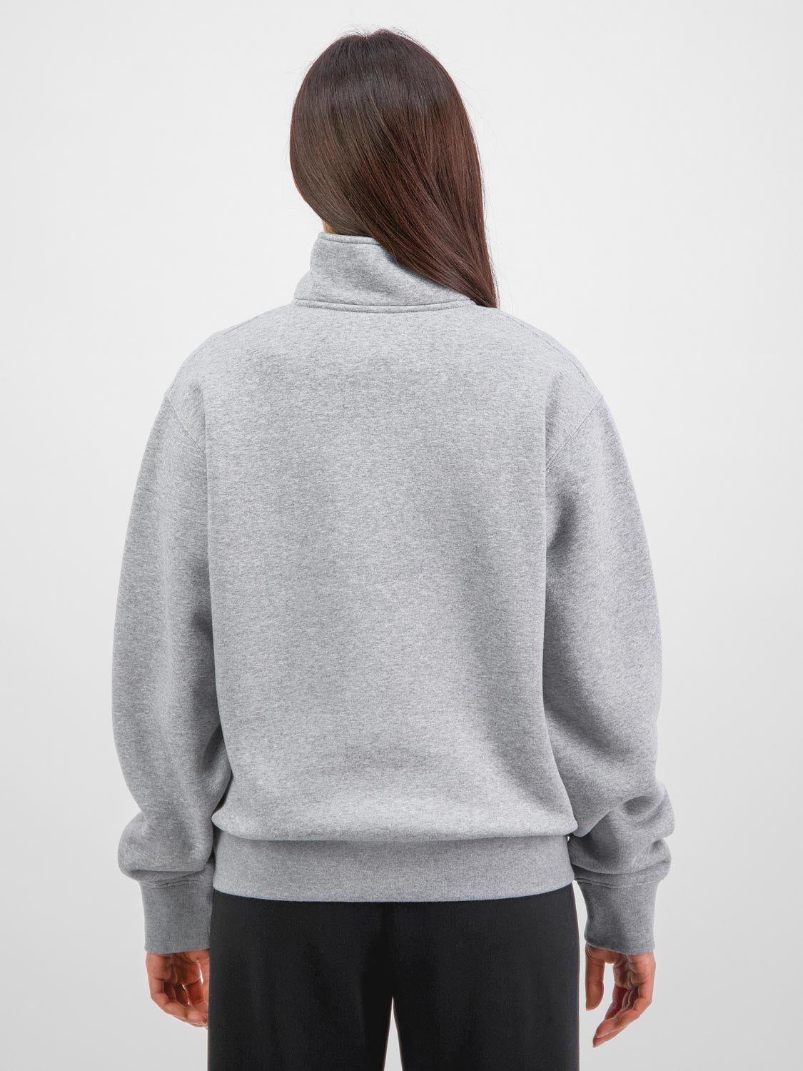 Rear view of a woman wearing a grey quarter-zip sweatshirt with ribbed cuffs and hem.